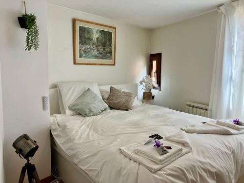 Una cama blanca con una bandeja encima. en Dove Nest, en Figeac