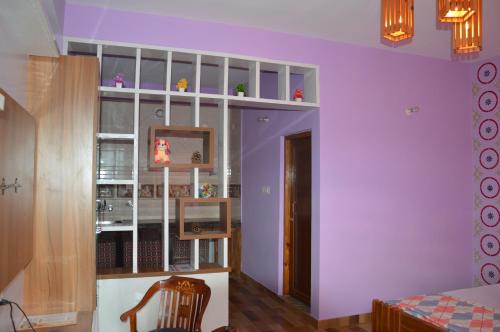 a living room with purple walls and a bedroom at The Banoak Homes Mashobra in Shimla
