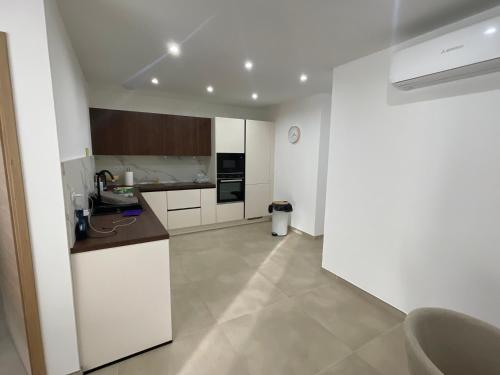 une cuisine avec des armoires blanches et un comptoir dans l'établissement Magnifique T4 alata, à Alata