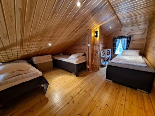 a room with two beds in a wooden cabin at Loma-Otso B in Kalajoki