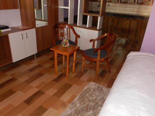 a bedroom with two chairs and a table and a bed at The Banoak Homes Mashobra in Shimla
