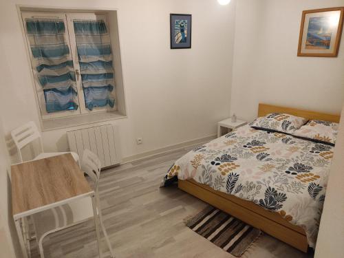 a bedroom with a bed and a table and a window at Appartement des machines in Nantes