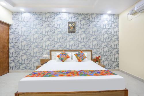a bedroom with a bed and a blue and white wall at Aditya Guest House in Varanasi