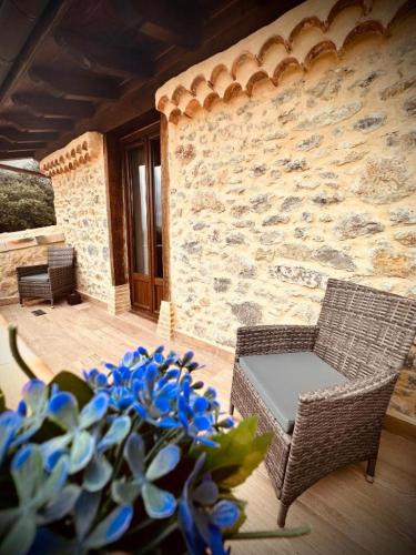 a patio with a chair and a table and blue flowers at La Quinta Luxury Palace in Arnuero