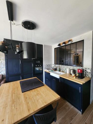 une cuisine avec des placards bleus et une table en bois dans l'établissement Appartement Lac de Vonnes Chatel, à Châtel