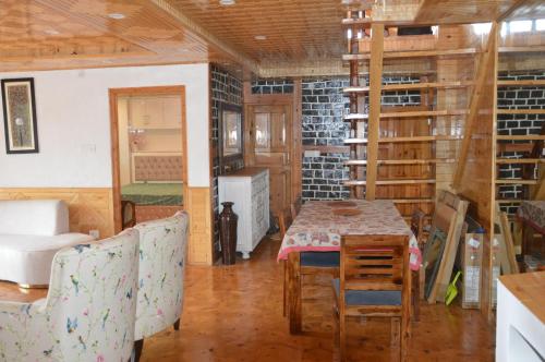 a room with a table and chairs in a room at The Banoak Homes Mashobra in Shimla