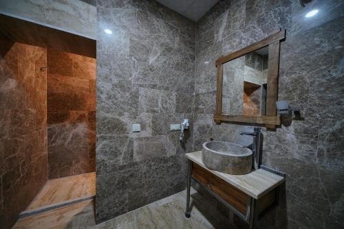 a bathroom with a sink and a mirror at Göreme Cave Lodge in Goreme