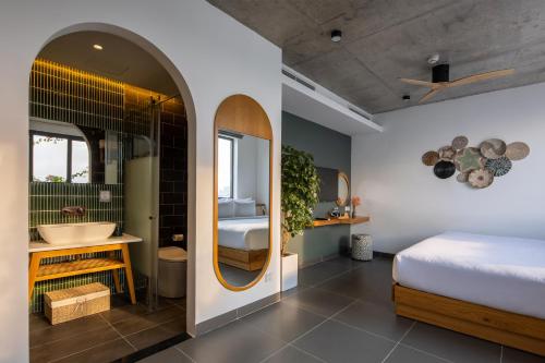 une chambre avec un lit et une salle de bain avec un lavabo dans l'établissement Leaf Beachfront Hotel Da Nang, à Đà Nẵng