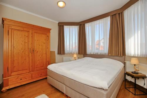 Un pat sau paturi într-o cameră la Dünenschloss Wohnung 1-41