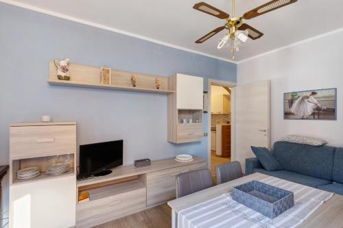 a living room with a blue couch and a television at Casabb in Toscolano Maderno