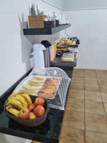 プレジデンテ・プルデンテにあるAvenida Hotelのカウンターに入ったフルーツバスケット付きテーブル