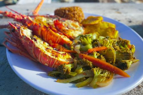 a plate of food with seafood and vegetables on a table at Villa Luz Coastal Sanctuary in Tintipan Island