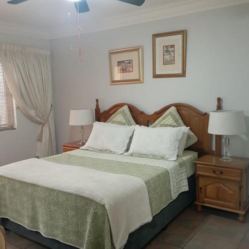 a bedroom with a bed with two night stands and two lamps at Avondale in Richards Bay
