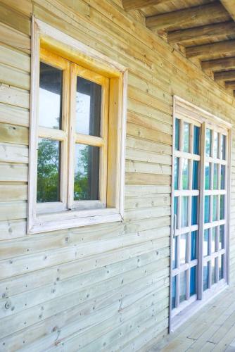 two windows on the side of a wooden house at Villa Luz Coastal Sanctuary in Tintipan Island