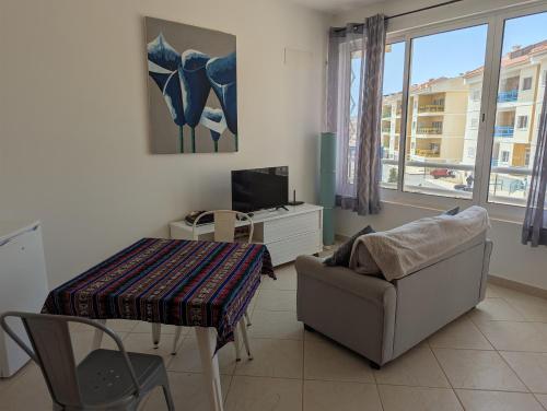 a living room with a couch a table and a television at Vila Cabral 2 Apartments - AC in Sal Rei