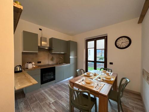 une cuisine et une salle à manger avec une table et une horloge dans l'établissement Casa Sally - Lago e montagna, à Cresciasca