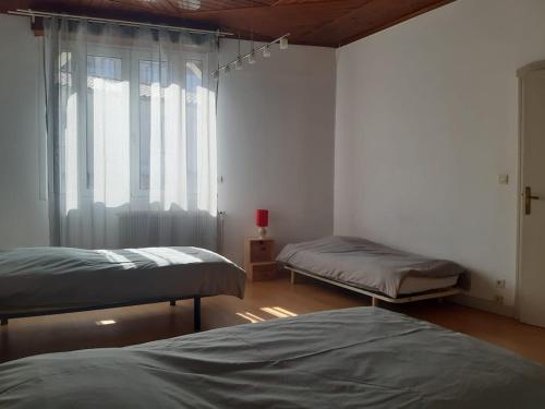 Cette chambre comprend 2 lits jumeaux et une fenêtre. dans l'établissement Maison 3 chambres - 25mn de Toulouse, à Caraman