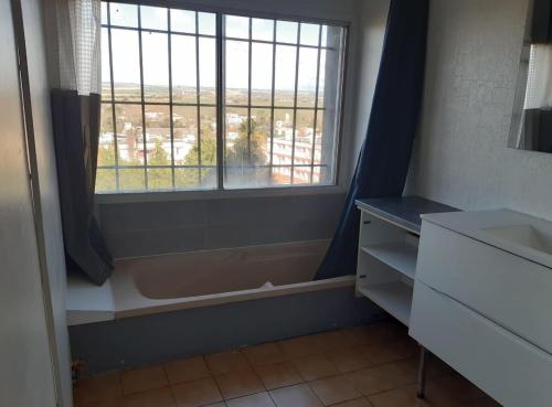 La salle de bains est pourvue d'une fenêtre, d'une commode et d'un lavabo. dans l'établissement Maison 3 chambres - 25mn de Toulouse, à Caraman