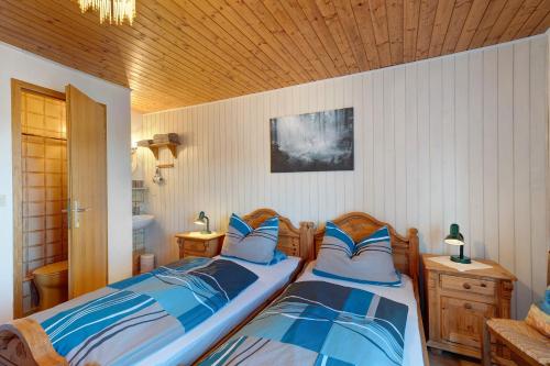 2 camas individuales en un dormitorio con techos de madera en Haus Hölltalblick, en Schönwald