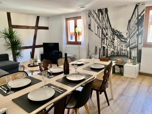 a dining room with a table and chairs at Au petit Herz'og in Wettolsheim