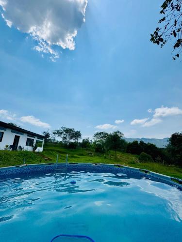 a large pool of blue water in front of a house at Piedras del Sol Casa Campestre in Guaduas