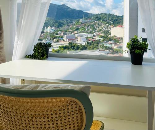 a table and a chair in front of a window at Aizen's haven at Casa Mira Guadalupe in Cebu City