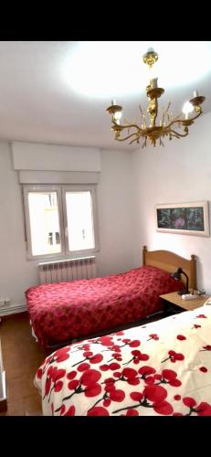 a bedroom with a bed with a red bedspread and two windows at Apartament 3 Bedrooms 80m2 Alto Campoo Reinosa Cantabria in Reinosa