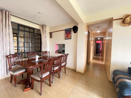 a dining room with a table and chairs at Lux Suites Thika Gateway Apartments in Thika