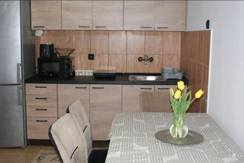 a kitchen with a table with a vase of flowers on it at Apartmani Djordjevic in Belgrade