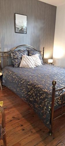 une chambre avec un lit avec une couette bleue dans l'établissement Maison, à Naucelles