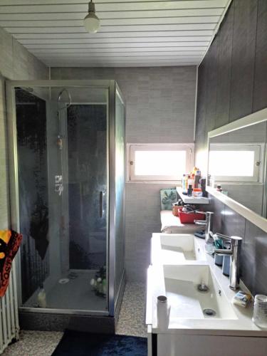 une salle de bain avec deux lavabos et une douche dans l'établissement Maison, à Naucelles