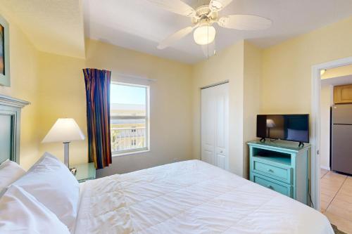 a bedroom with a white bed and a television at Sunset Dreams in St Pete Beach