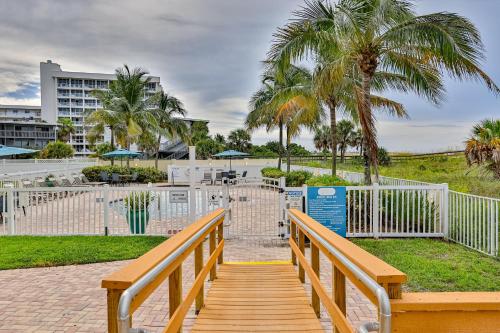 a wooden boardwalk leading to a park with palm trees at Sunset Dreams in St Pete Beach