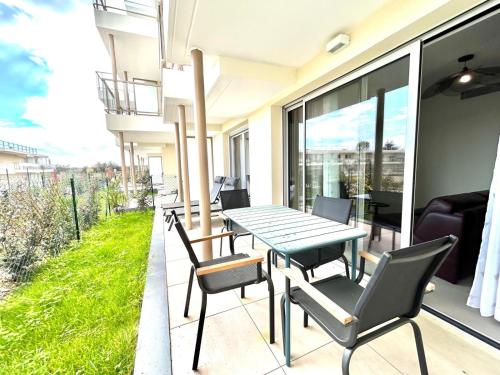 un patio avec une table et des chaises sur un balcon dans l'établissement 2 Rooms Villeneuve-Loubet, à Villeneuve-Loubet