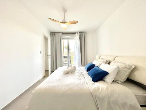 une chambre avec un grand lit blanc avec des oreillers bleus dans l'établissement 2 Rooms Villeneuve-Loubet, à Villeneuve-Loubet