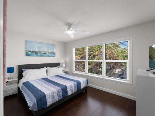 ノースポートにあるTranquil Waterfront Retreat w Scenic Views-Heated Poolのベッドと2つの窓がある寝室