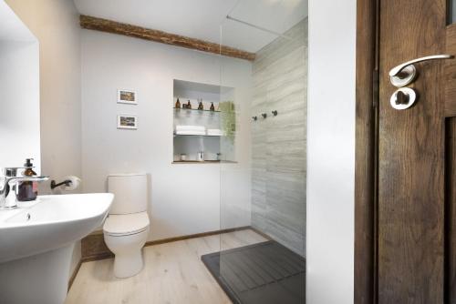a bathroom with a shower and a toilet and a sink at Riverside - Quaint County Cottage overlooking the Beck in Caldbeck