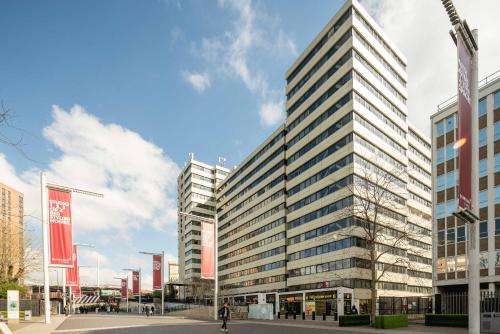 a tall building with many windows on a street at Wembley Stadium Apartments by Sleepy Lodge London in London