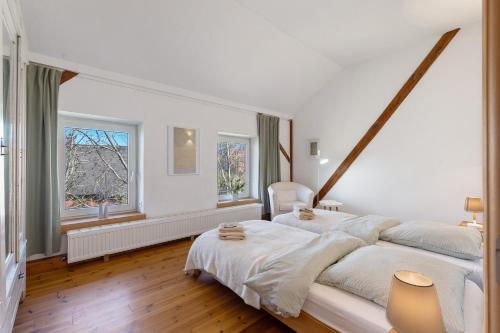 MeezenにあるWerkgut - Charmantes Loftの白いベッドルーム(大型ベッド1台、窓2つ付)
