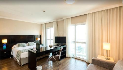 a hotel room with a bed and a desk with a computer at Perdizes Flats in Sao Paulo