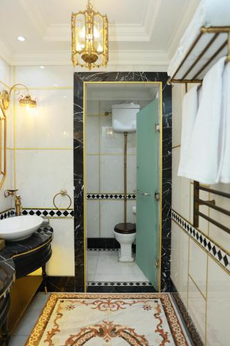 a bathroom with a toilet and a sink at Golden Palace Hotel Yerevan in Yerevan