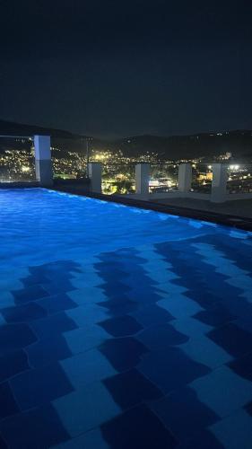 a large swimming pool at night with a city at Tu mejor opción por san gil in San Gil