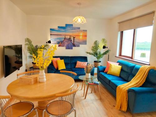 a living room with a blue couch and a table at Happy Sandy Feet in Youghal