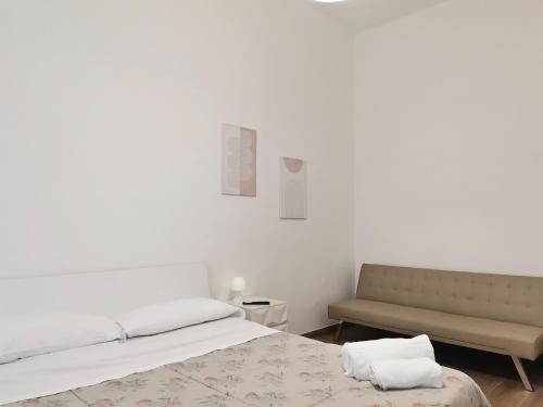 a white bedroom with a bed and a bench at VerdeMare Big House in Torre a Mare