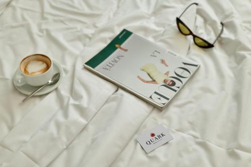 a book and a cup of coffee on a bed at Quark Hotel Milano in Milan