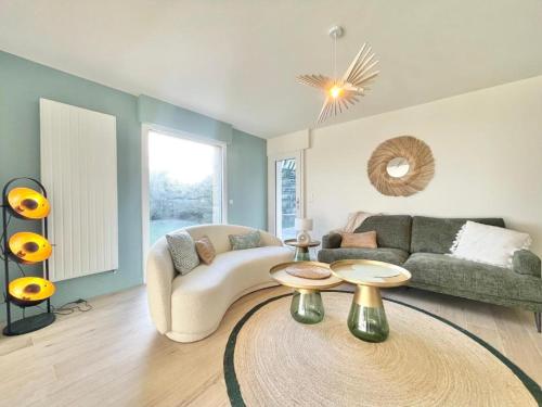 un salon avec un canapé et une table dans l'établissement Villa Breizh - Front de mer - Accès plage - 8 personnes, à La Forêt-Fouesnant