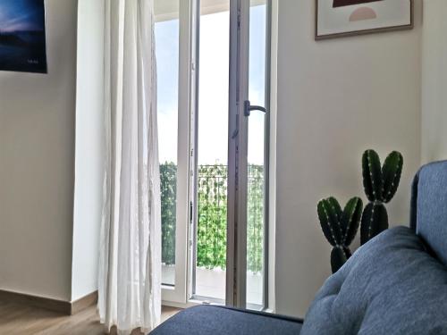 a living room with a couch and a large window at VerdeMare Big House in Torre a Mare