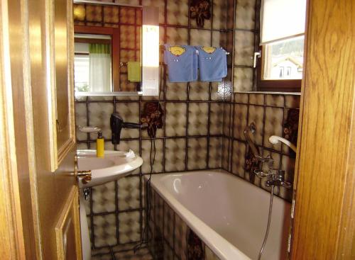 ein Badezimmer mit einer Badewanne und einem Waschbecken in der Unterkunft Appartement Milli in Längenfeld