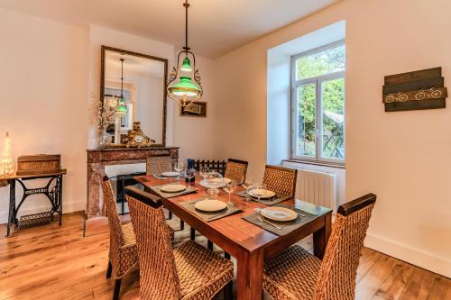 une salle à manger avec une table et des chaises et une cheminée dans l'établissement Villa Montcalm, à Ax-les-Thermes