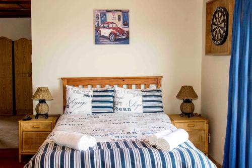 a bedroom with a bed with two night stands and two lamps at Victoria Heights B&B in George